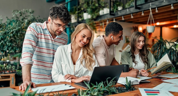 Multiracial creative people in modern office. Group of young business people and senior boss are working together with laptop, tablet, smart phone, notebook, graphs. Successful team in coworking