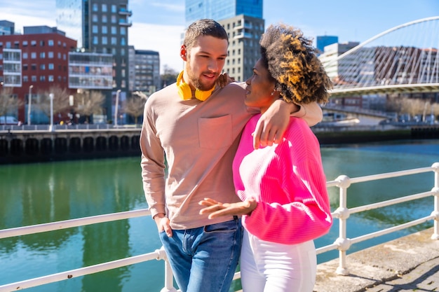 Multiracial friends on the streets of the city lifestyle concept walking and laughing by the river