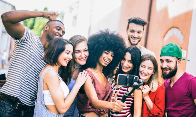 Multiracial friends taking video selfie with mobile phone on stabilized gimbal