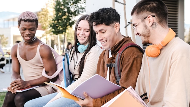 Multiracial group of friends studying together sitting in a park