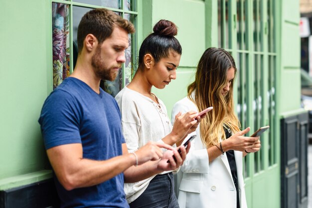 Multiracial group of people looking down at smart phone