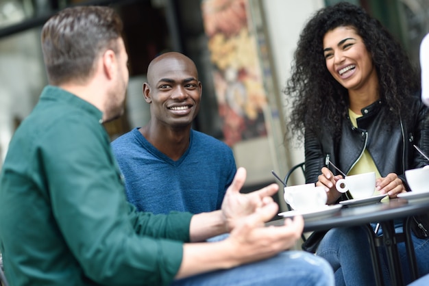 Multiracial group of three friends having a coffee together.