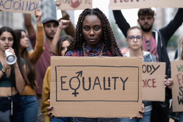 Multiracial group of young people walking together protesting for equality and human rights against racism