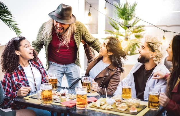 Multiracial guys and girls drinking beer pints at balcony patio