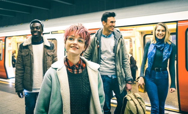 Multiracial hipster friends group walking at tube subway station