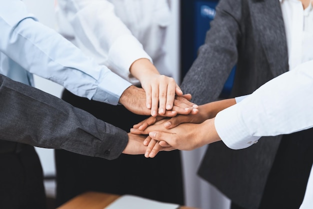 Multiracial office worker's hand stack shows solidarity teamwork and trust in diverse community Businesspeople unite for business success through synergy and collaboration by hand stacking Concord