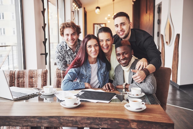 Multiracial people having fun at cafe taking a selfie with mobile phone