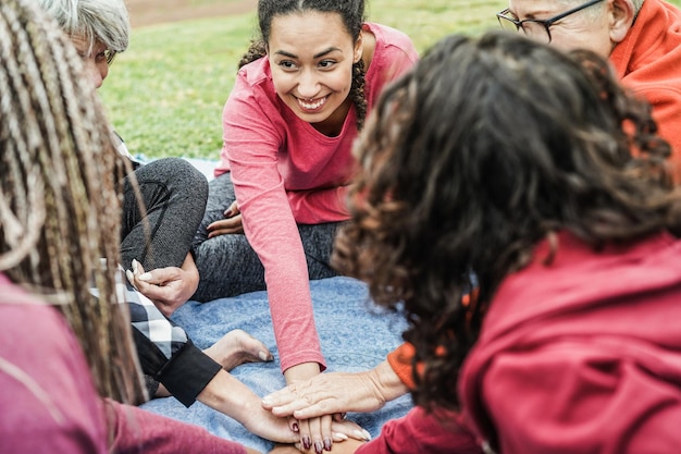 Multiracial people stacking hands outdoor at city park  Focus on african girl face