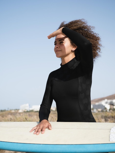 Multiracial surfer girl portrait watching the waves