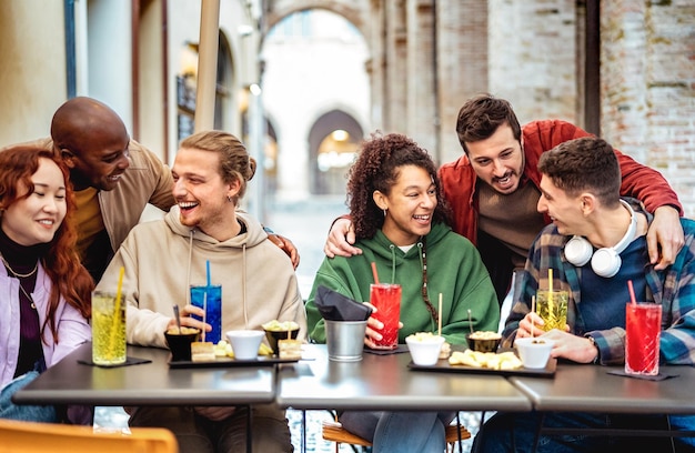 Multiracial trendy friends having fun moment at fancy cocktail bar