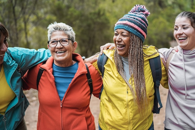 Multiracial women having fun during trekking day in to the wood - Focus on african female face