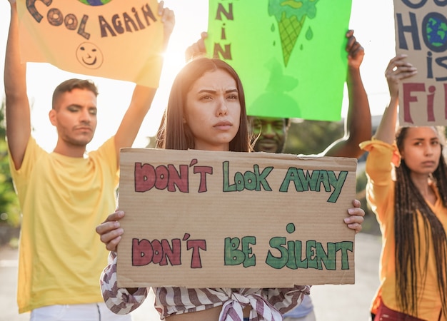 Photo multiracial young people demonstrate on the street with banner for the climate change