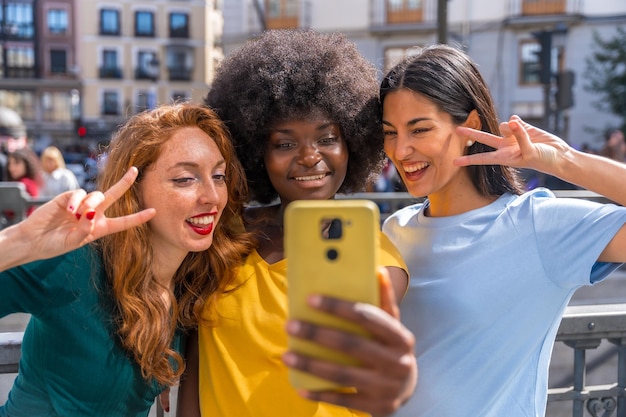 Multiracial young women taking a selfie in the city friendship and feminism