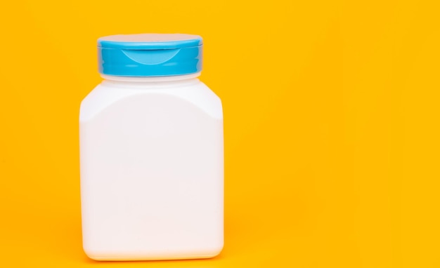 Multivitamin bottle on yellow background. copy space. food supplement.