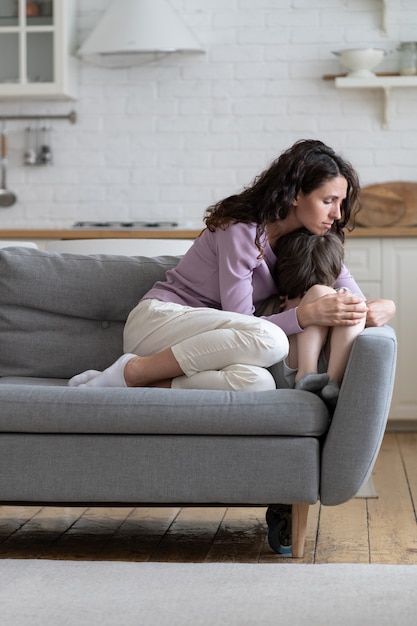 Mum consoling crying depressed son after family quarrel caring mother comfort stressed small boy