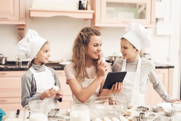 Mum and Kids Searching for Food Recipes Holds Egg.