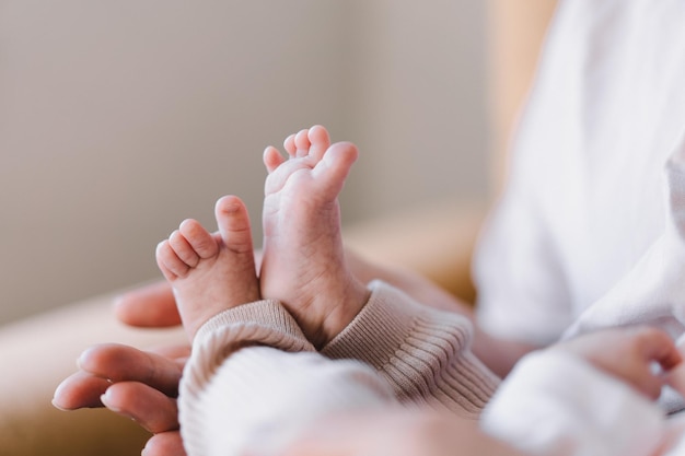 Mum making baby massage mother massaging infant bare foot preventive massage for newborn mommy stroking the baby's feet with both hands Love baby Newborn baby and mother