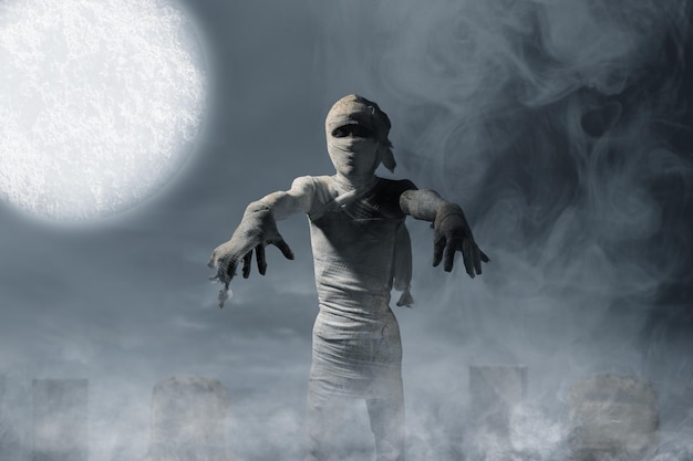 Mummy standing in the graveyard with a night scene background Scary Halloween concept