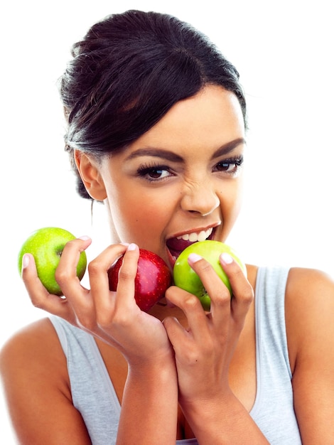 Munching on the healthy stuff Studio portrait of a young woman in gymwear holding apples