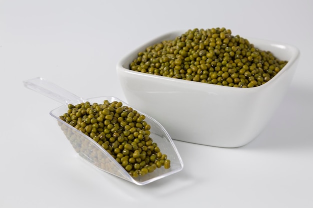 Mung bean in bowl and plastic spoon on white background studio shot