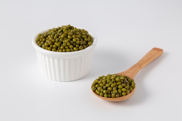 Mung bean in bowl and wood spoon on white background studio shot