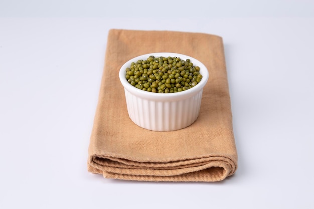 Mung bean in white bowl on cloth and white background studio shot