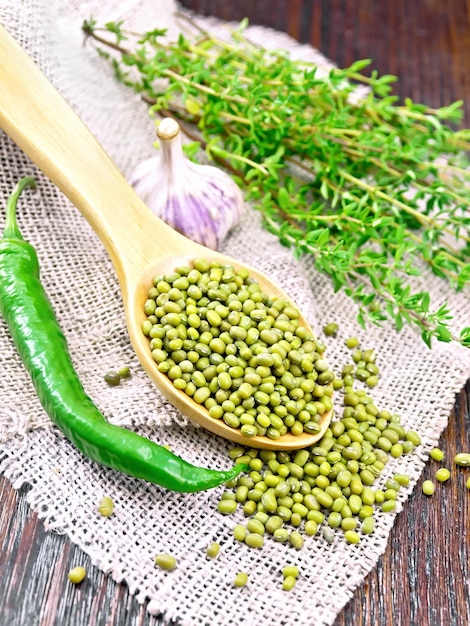 Mung beans in spoon on dark board