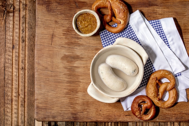 Munich Bavarian traditional white sausages in ceramic pan served with german sweet mustard