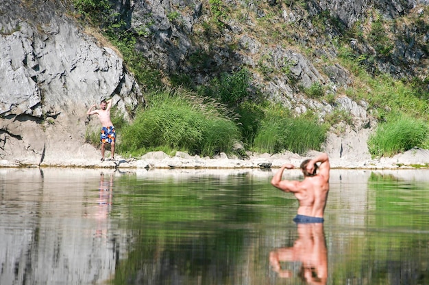 Muscled in the river on a background of skinny guy