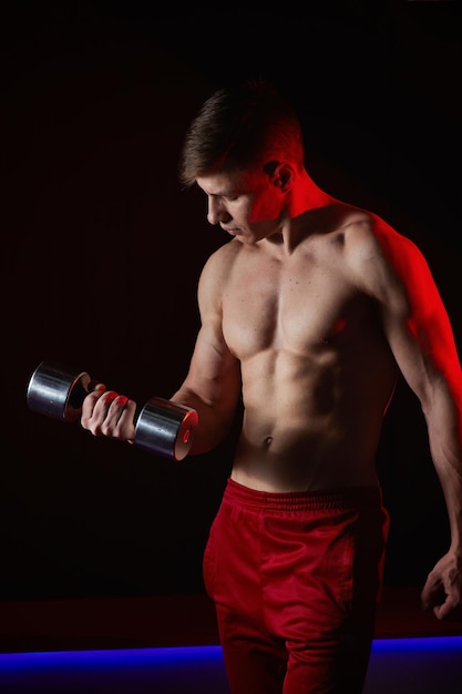 Muscular athlete man exercise on a black background