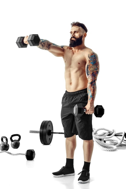 Muscular bodybuilder guy doing exercises with dumbbells over white background