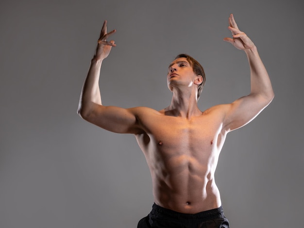 Photo muscular man in an artistic pose portrait on a gray background