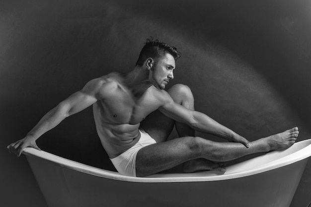 Muscular man on bathtub