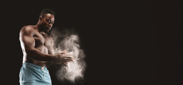 Photo muscular man clapping chalk before workout