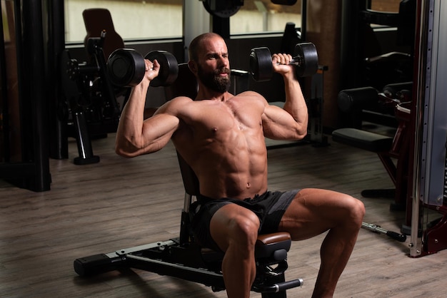 Muscular Man Exercising Shoulders With Dumbbell