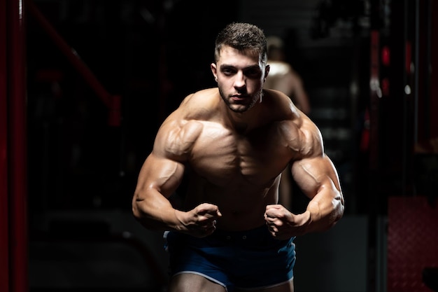 Muscular Man Flexing Muscles In Gym