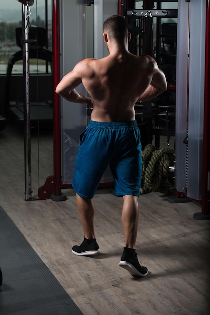 Muscular Man Flexing Muscles In Gym