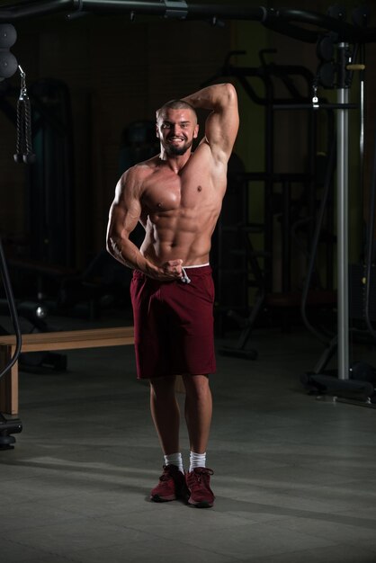 Muscular Man Flexing Muscles In Gym