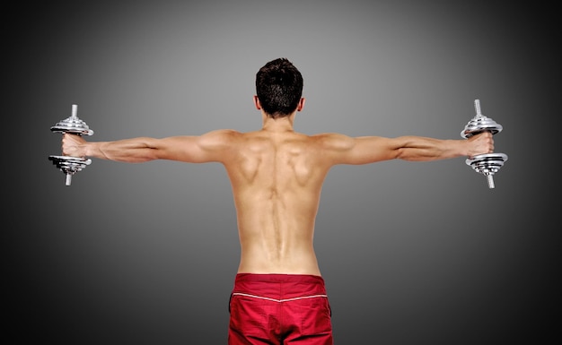 Muscular man lifting dumbbells