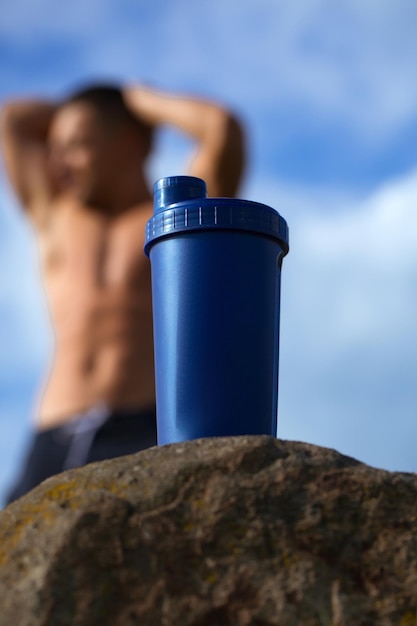 Muscular man relaxing near water bottle