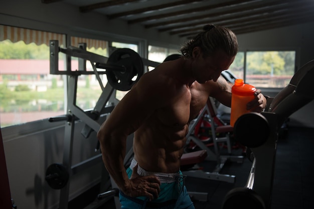 Muscular Man Resting After Exercise And Drinking From Shaker