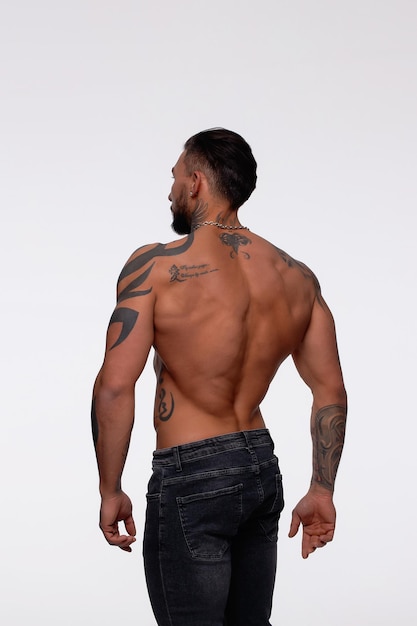 Muscular shirtless tattooed guy in studio