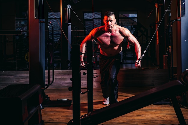 Muscular and strong guy exercising strong muscular man works out pushing up excercise in gym exercis