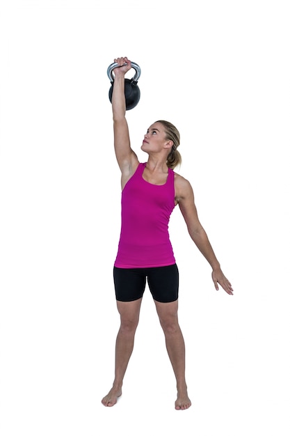 Muscular woman exercising with kettlebell 