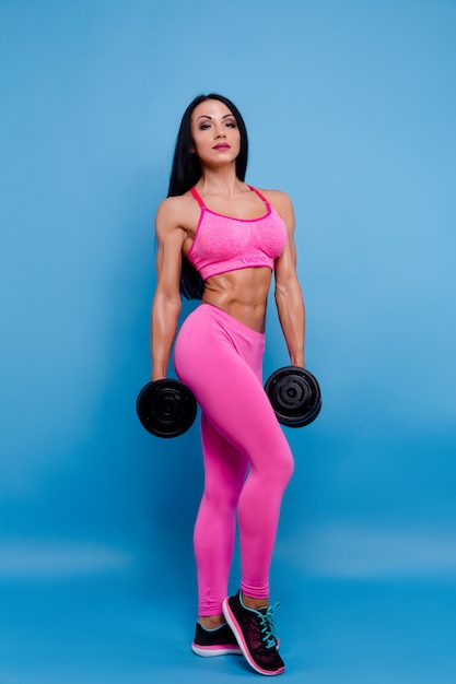 Muscular woman holding dumbbells