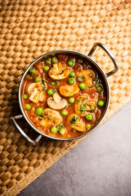 Photo mushroom and pea curry with roasted garlic indian food served in a bowl