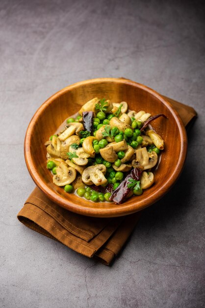 Photo mushroom and pea curry with roasted garlic indian food served in a bowl