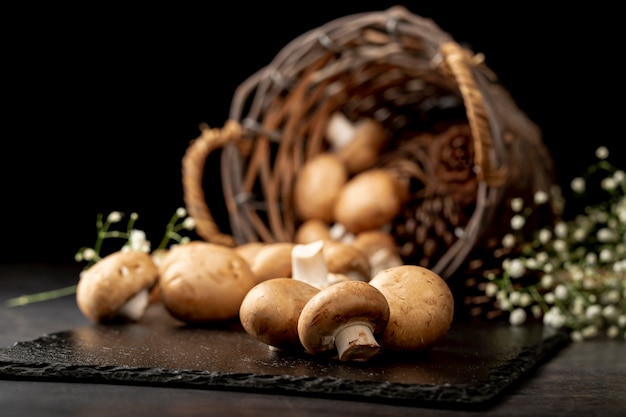 Mushrooms on a black stone plate with a brown knitted basket