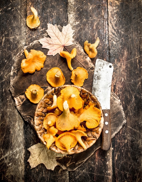 Mushrooms chanterelle in the basket. On a wooden background.