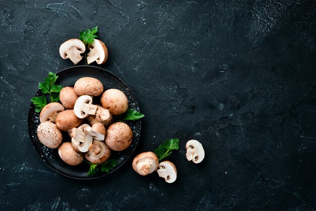 Mushrooms in a plate Champignons on the old background Top view Free copy space